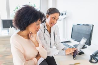 Young woman talking with her OB-GYN in the clinician's office.